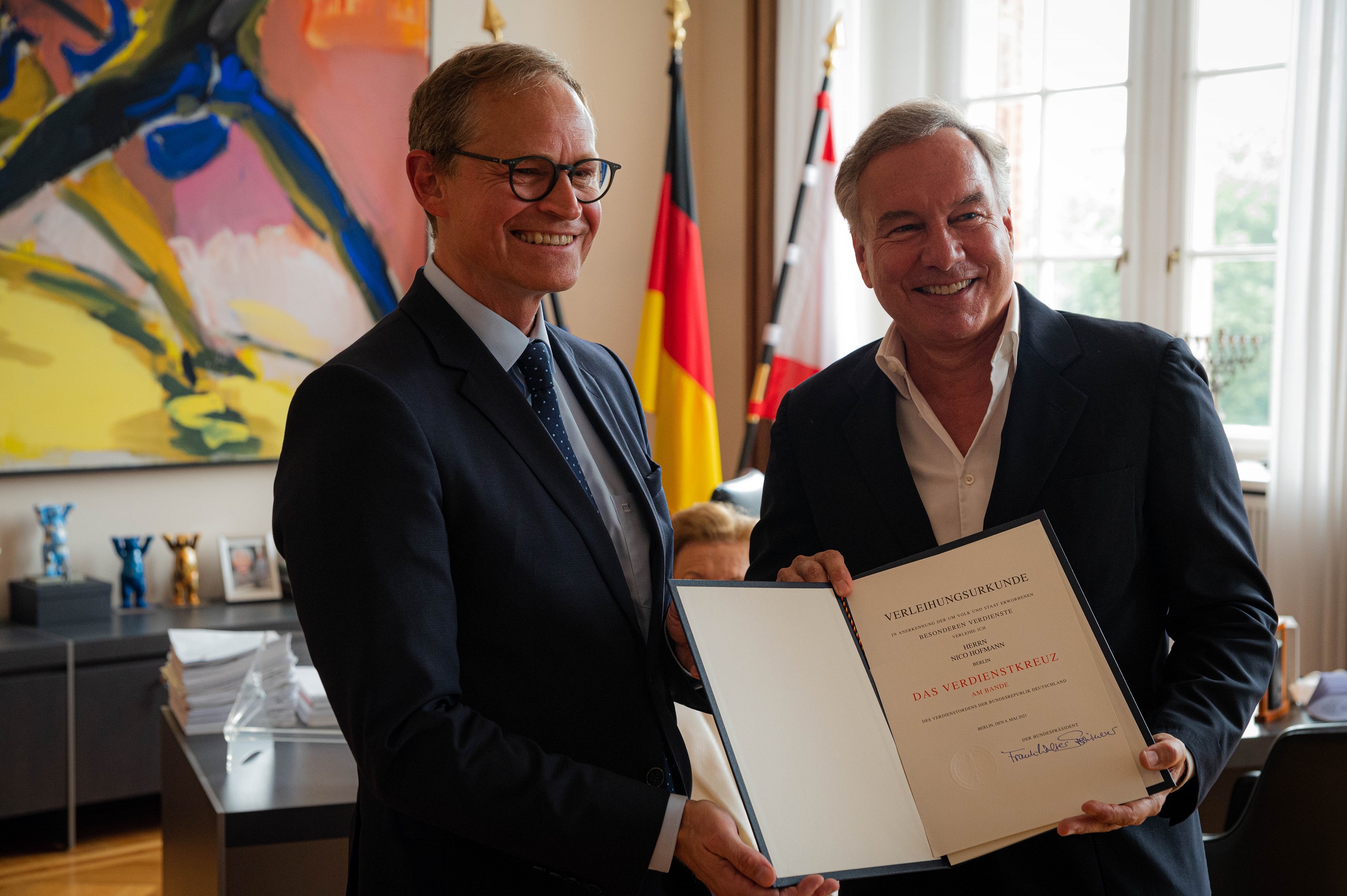 Der Regierende Bürgermeister von Berlin Michael Müller überreicht Nico Hofmann die Urkunde