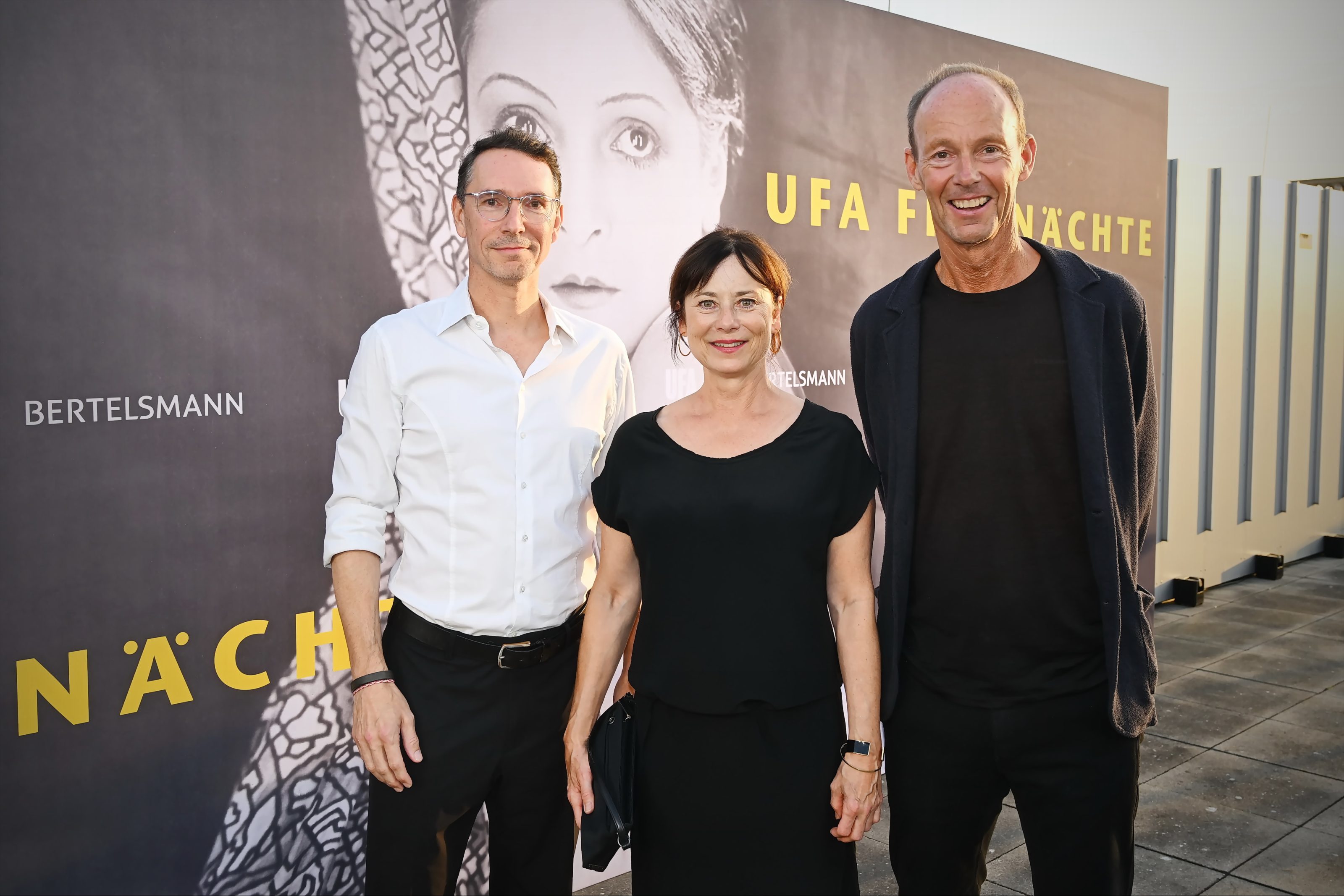 Die Gastgeber des Abends: Sascha Schwingel (CEO UFA) und Thomas Rabe (Vorstandsvorsitzender von Bertelsmann) mit Filmpatin Inka Friedrich bei dem Empfang anlässlich der 15. UFA Filmnächte, die vom 27.-29.8. auf der Berliner Museumsinsel restaurierte Fassungen aus der Stummfilmära zeigen.